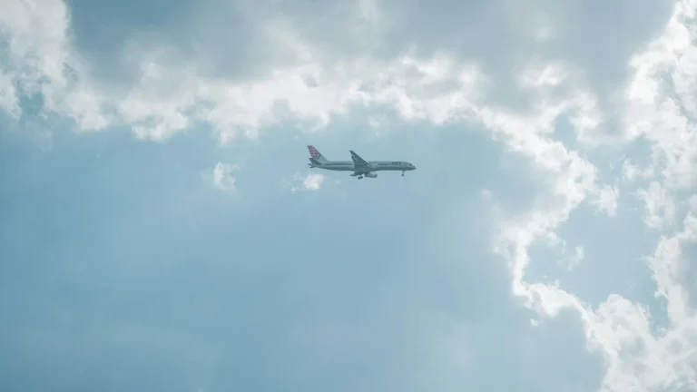 aereo di linea moderno che vola sopra le nuvole al tramonto