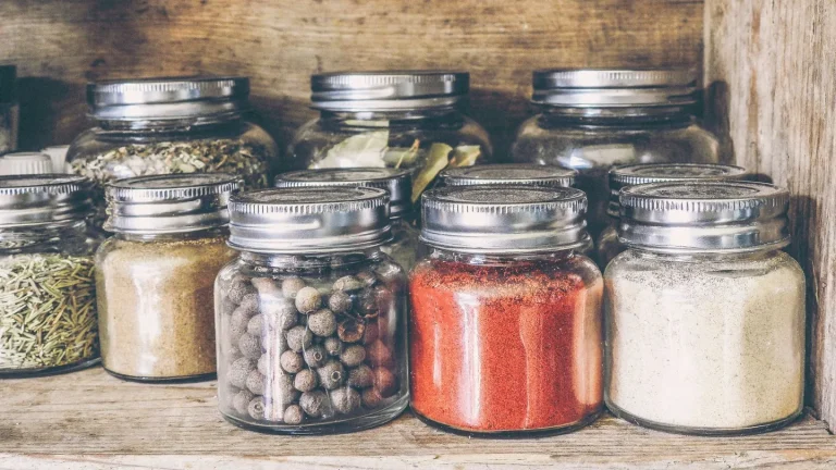 Persona che controlla i barattoli di spezie in cucina per verificare un richiamo alimentare