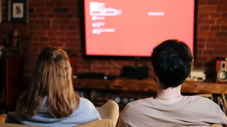 Famiglia italiana seduta sul divano che guarda un film in streaming a casa