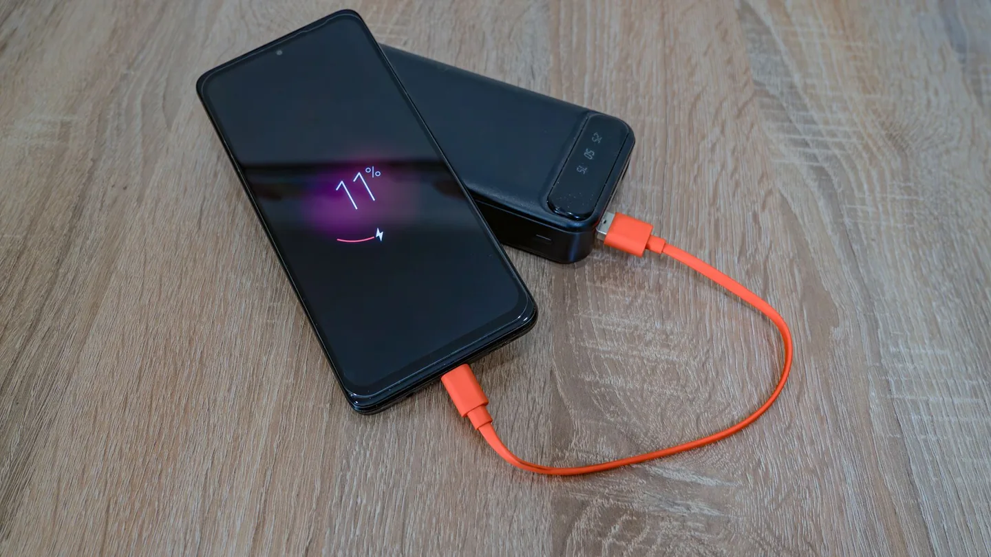 Smartphone appoggiato su un tavolo collegato a un caricatore rapido