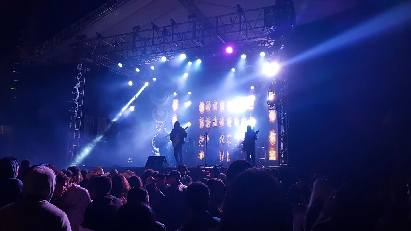 Cantante rock sul palco che saluta il pubblico in un grande arena durante un concerto