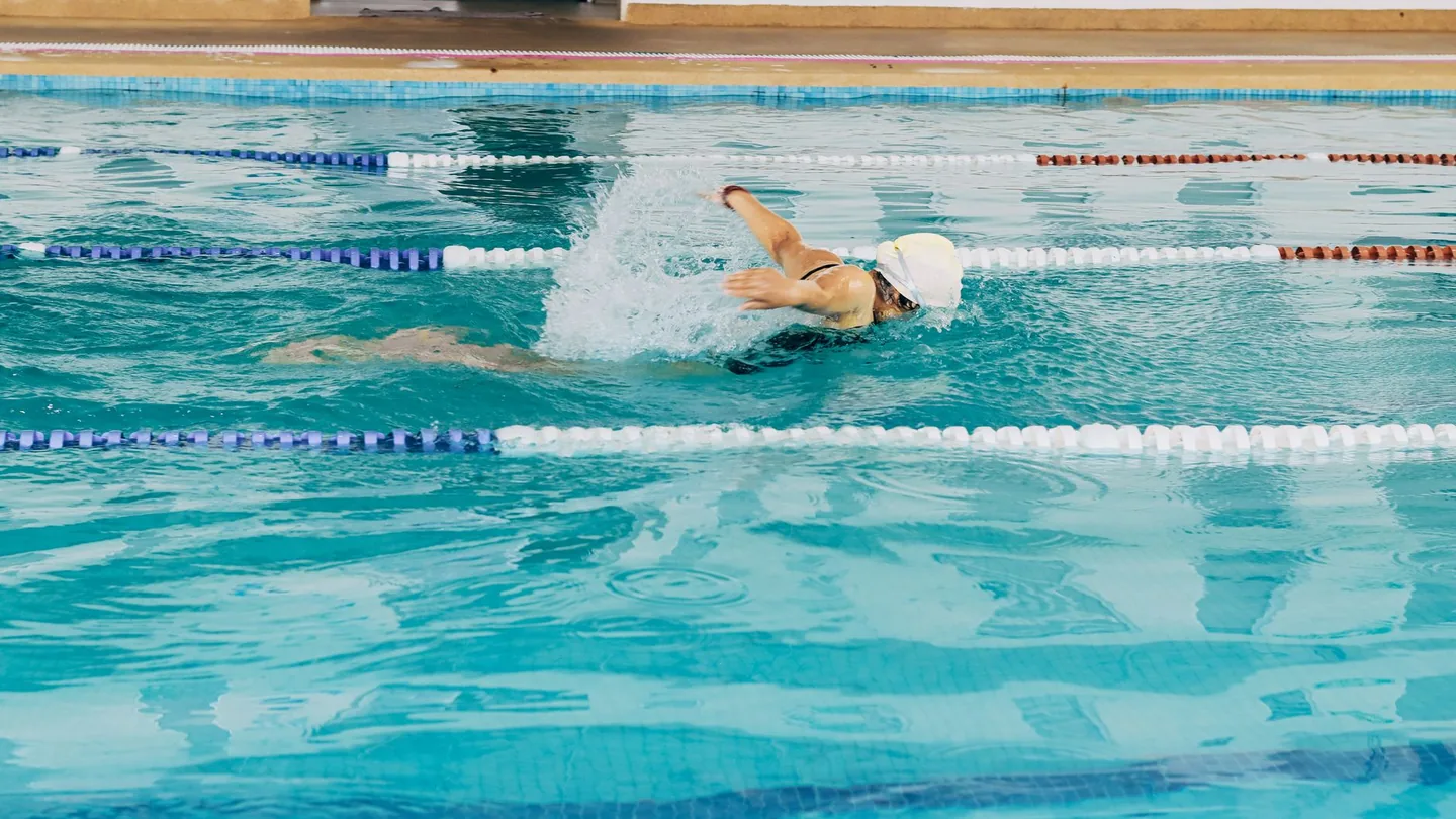 Donna che nuota a stile libero in una piscina coperta