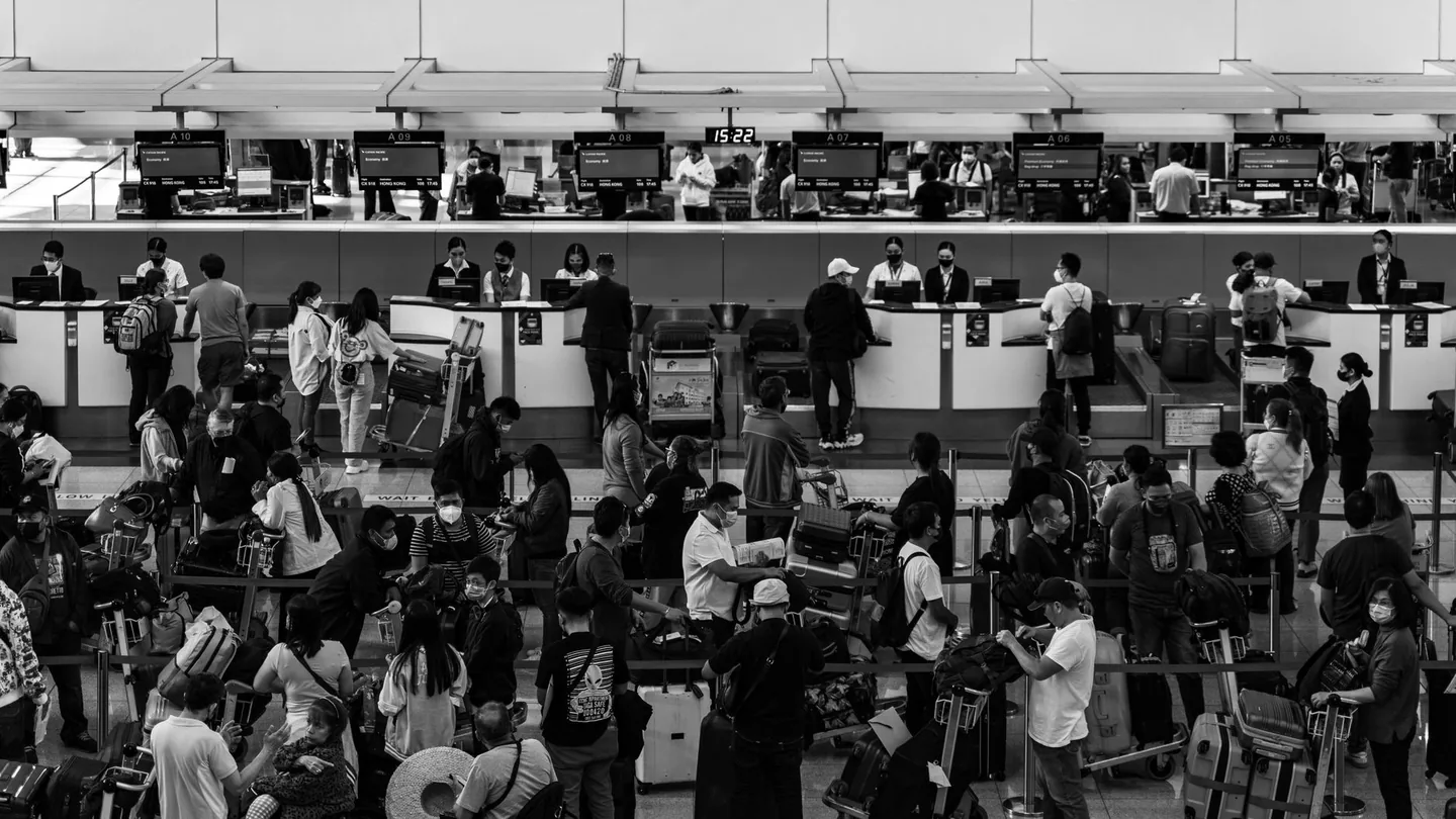 Viaggiatori in aeroporto con passaporti e valigie in attesa del volo